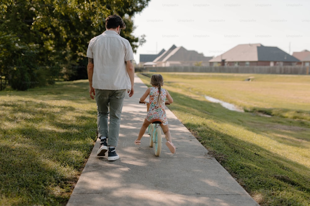 a man and a little girl walking down a sidewalk