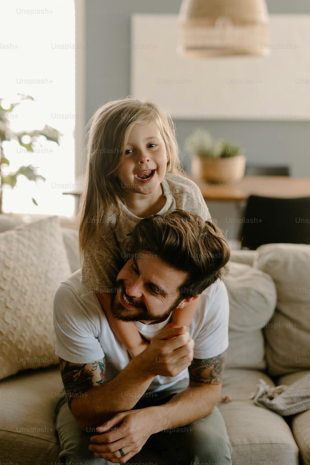 a man holding a little girl while sitting on a couch