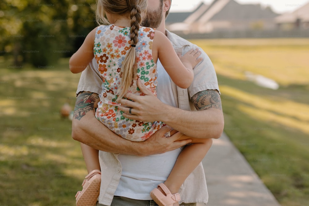 Un homme tenant une petite fille dans ses bras