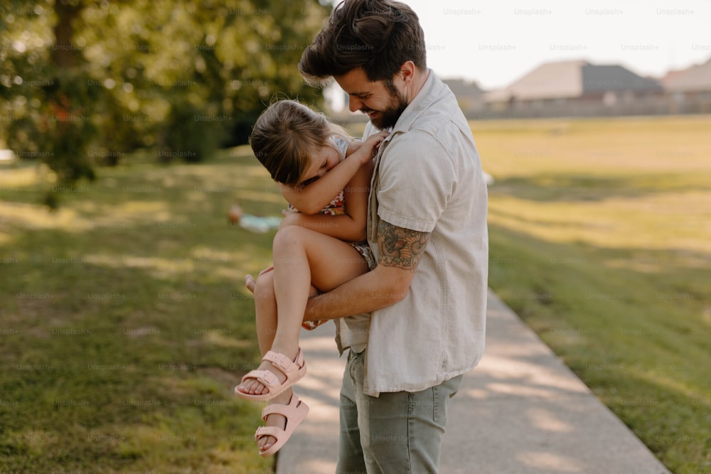 Un hombre sosteniendo a una niña en sus brazos