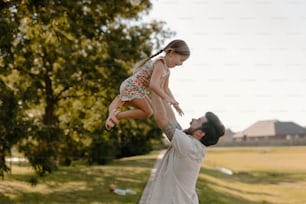 a man holding a little girl in the air