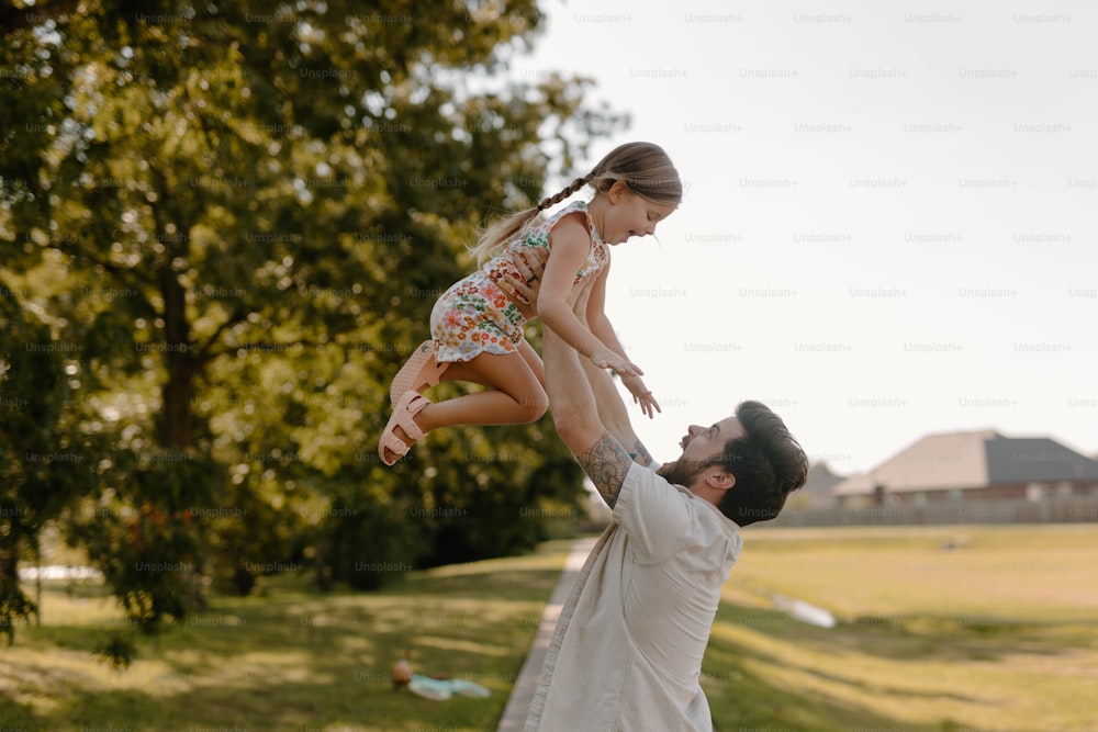 a man holding a little girl in the air