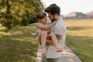 a man holding a little girl in his arms