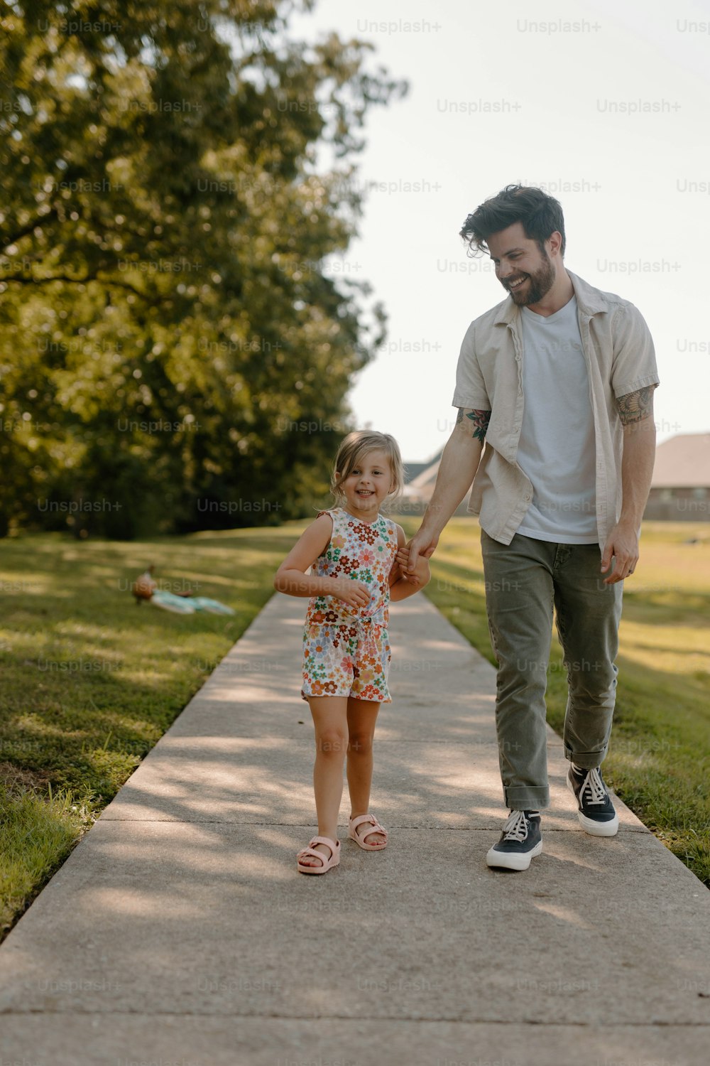 um homem e uma menina caminhando por uma calçada