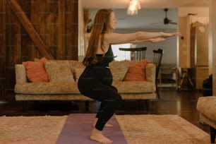 a woman doing a yoga pose in a living room