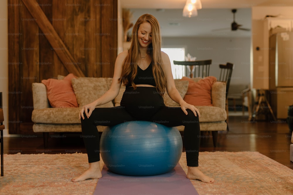 a woman sitting on a yoga ball in a living room