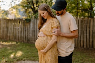 Un uomo e una donna incinta in piedi l'uno accanto all'altro