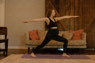 Una donna che fa una posa yoga davanti a un divano