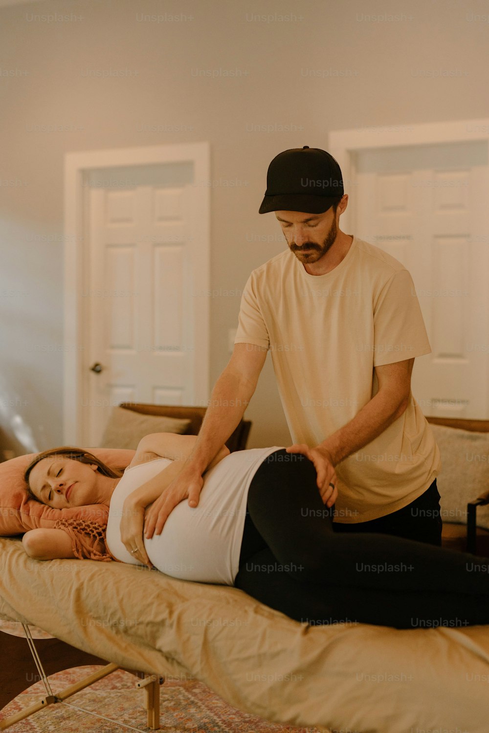 a man standing over a woman laying on a bed