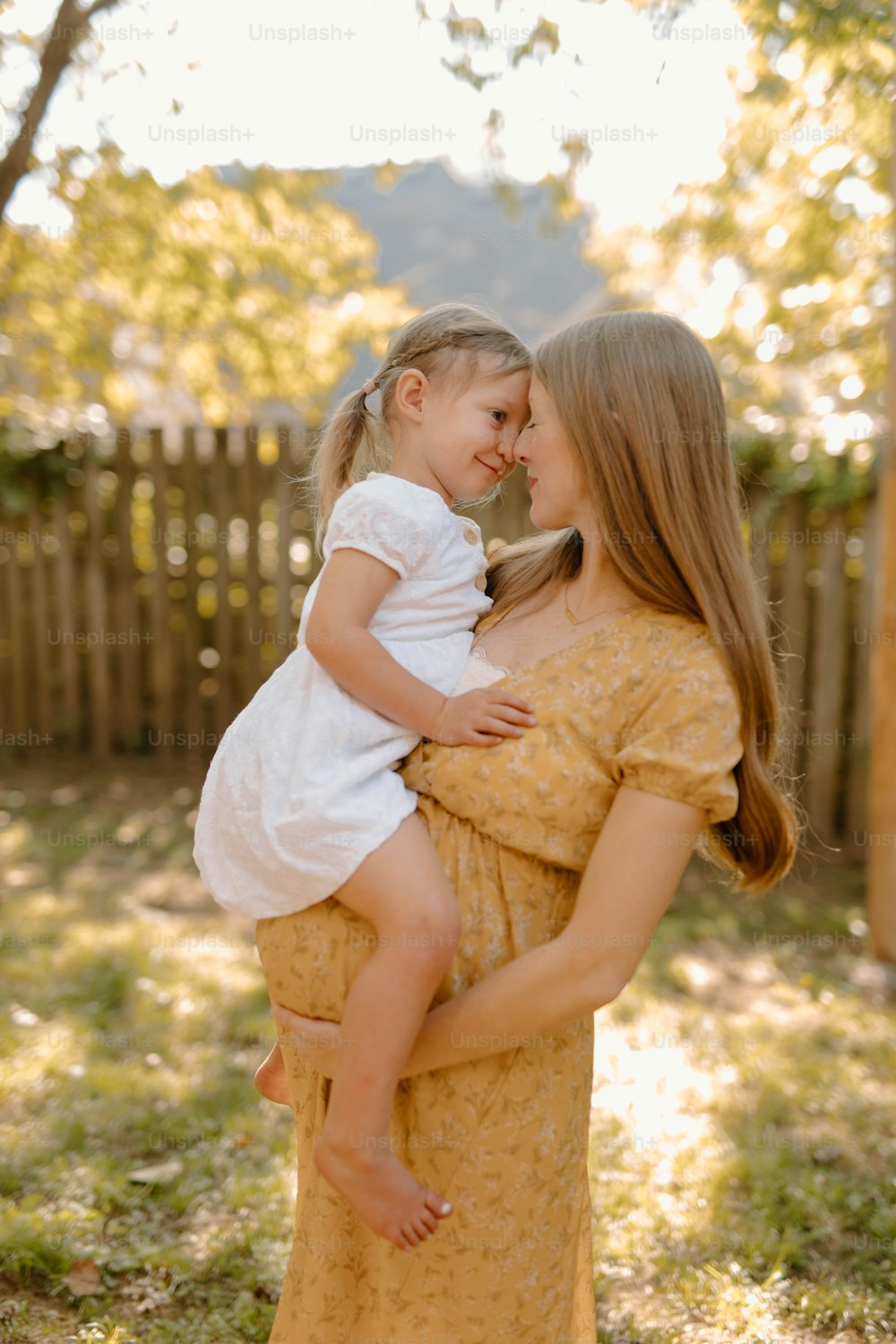 a woman holding a little girl in her arms