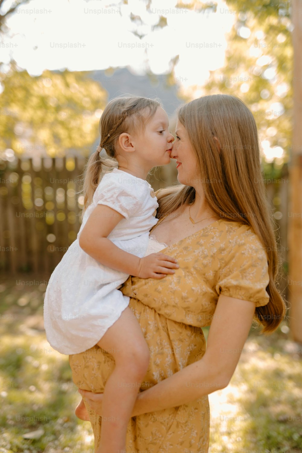 a woman holding a little girl in her arms