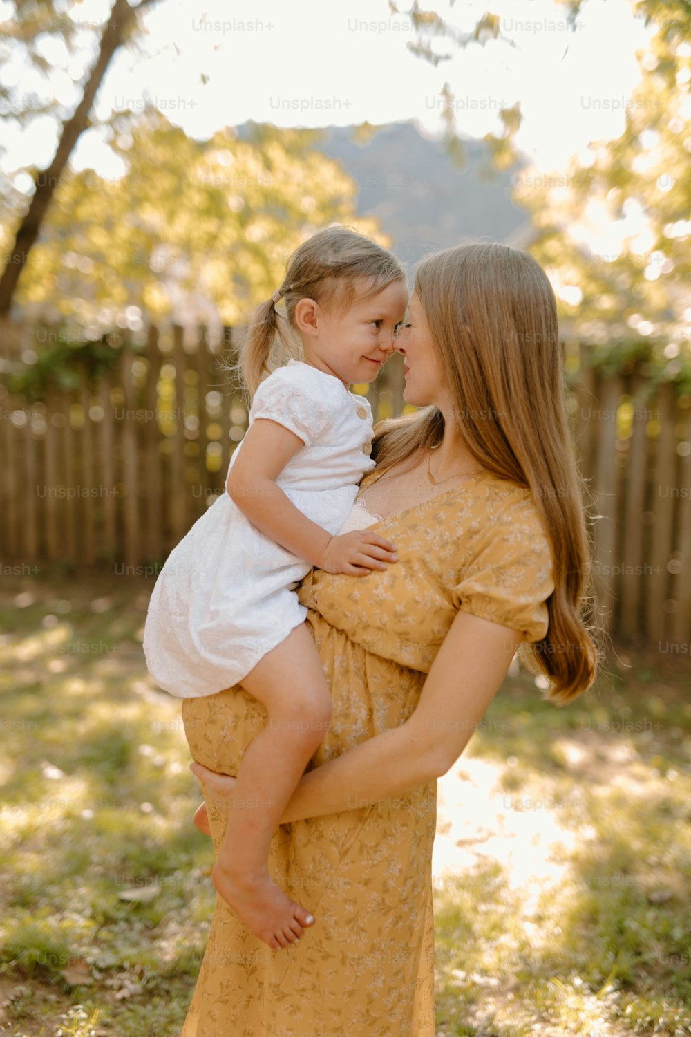 a woman holding a little girl in her arms