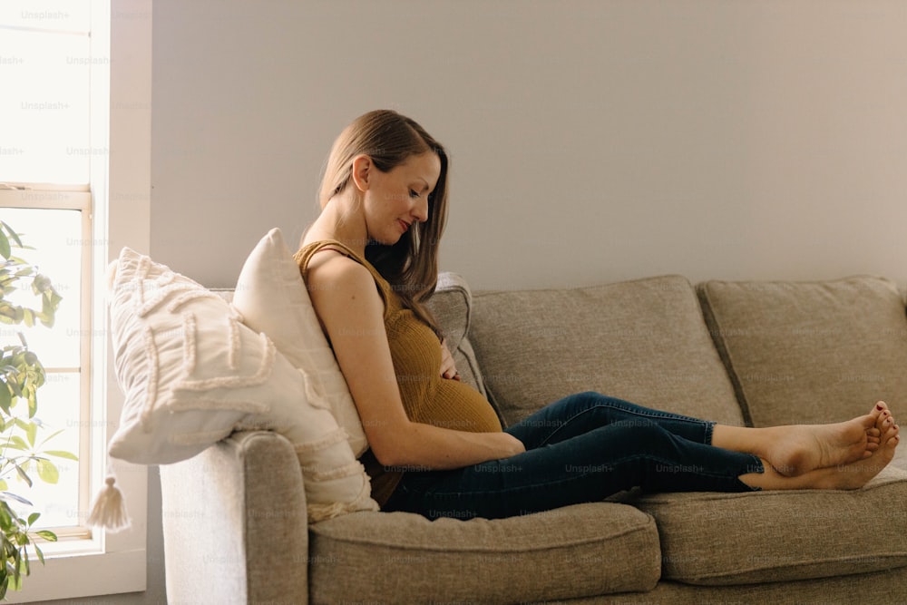 Una donna seduta su un divano con le gambe incrociate