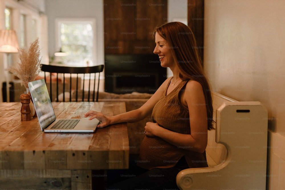 노트북 컴퓨터를 사용하여 테이블에 앉아 있는 여자