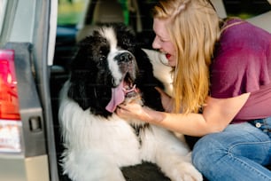 a woman petting a large black and white dog