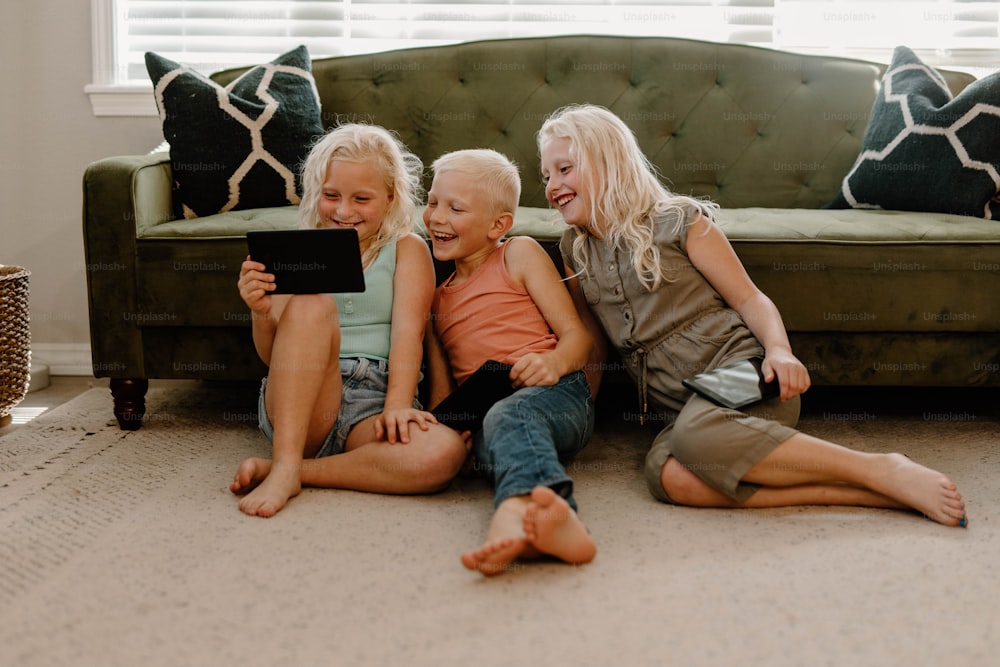 a group of children sitting on the floor next to a couch