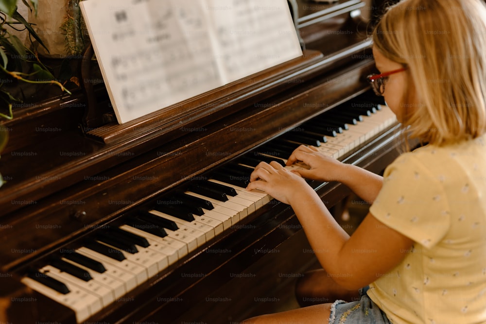 a young girl is playing a piano in a room