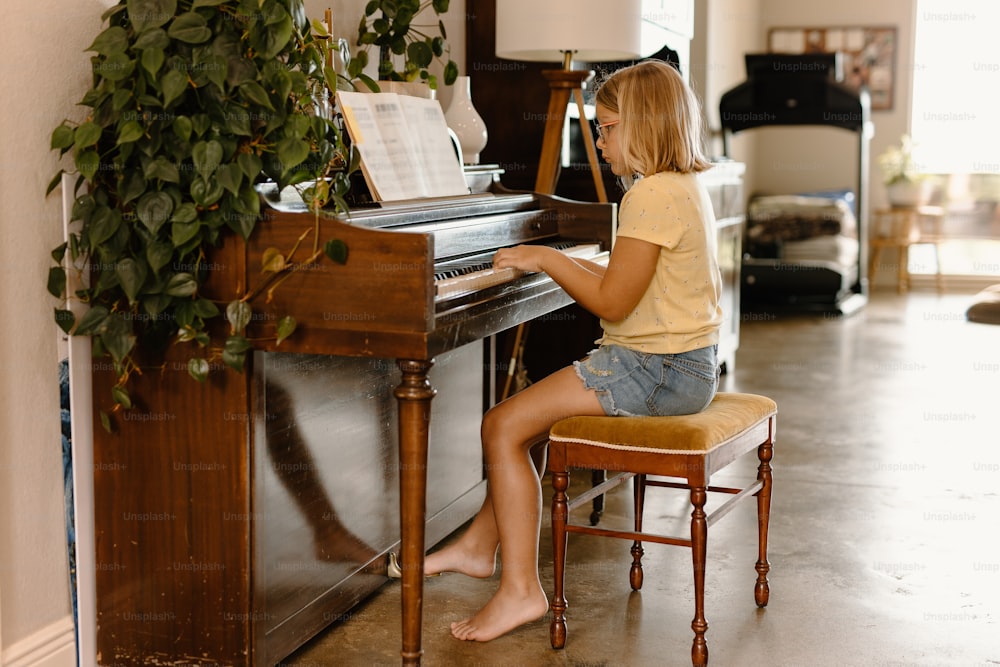 居間でピアノの前に座る女性