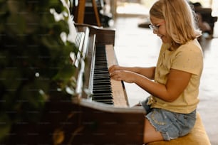 a young girl playing a piano in a room
