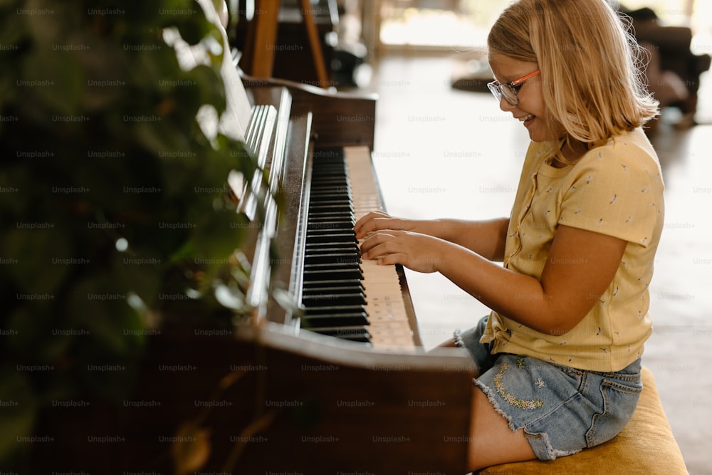 a young girl playing a piano in a room