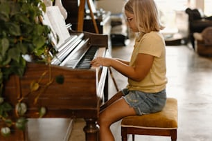 a young girl sitting at a piano playing the piano