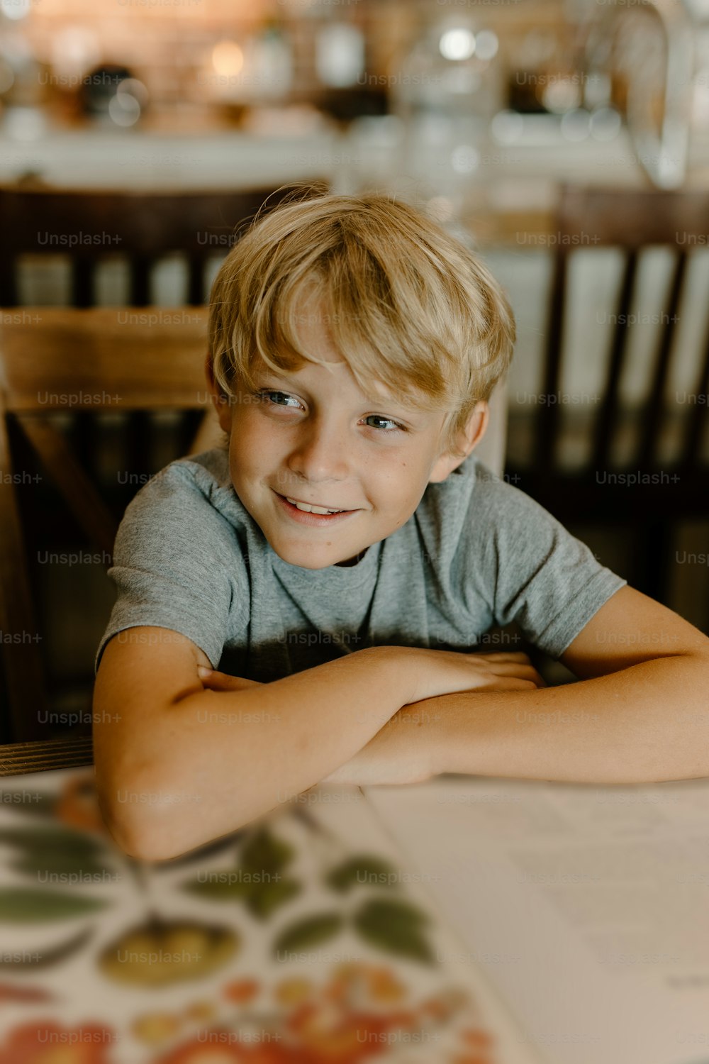 a young boy sitting at a table with a book
