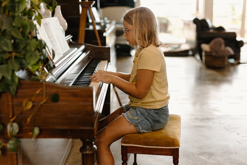 거실에서 피아노 앞에 앉아 있는 어린 소녀