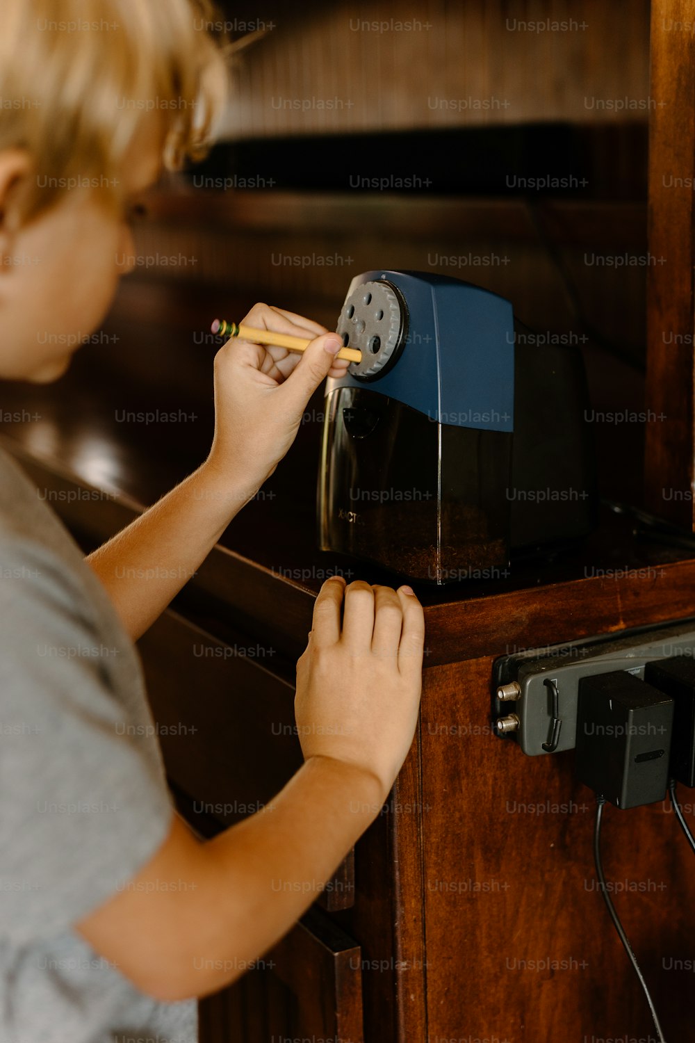a young boy is putting a pencil in a toaster