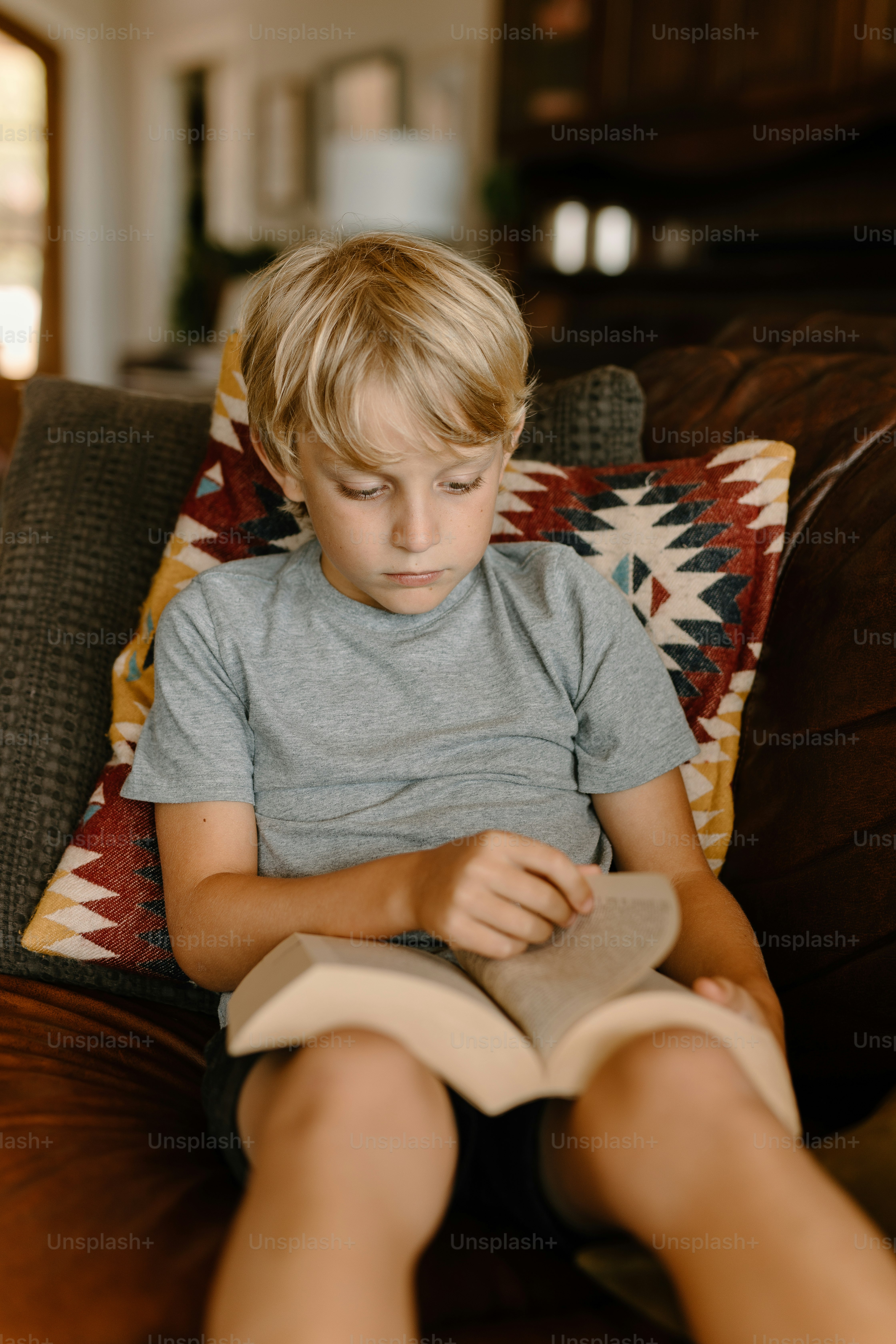 ソファに座って本を読む少年