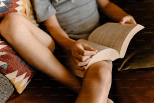 a person sitting on a couch reading a book