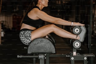 a woman sitting on a bench with a barbell