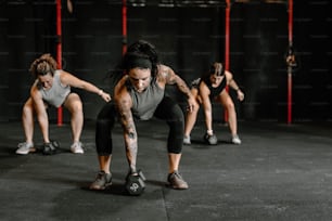 a group of women doing push ups in a gym