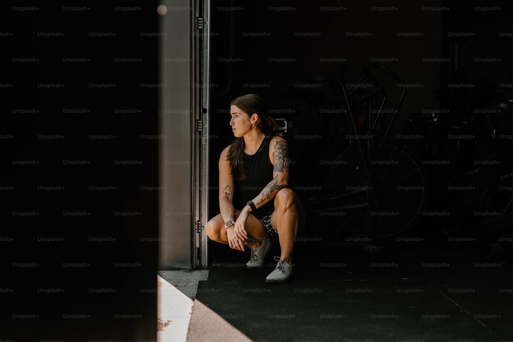 a woman sitting on a step in a dark room