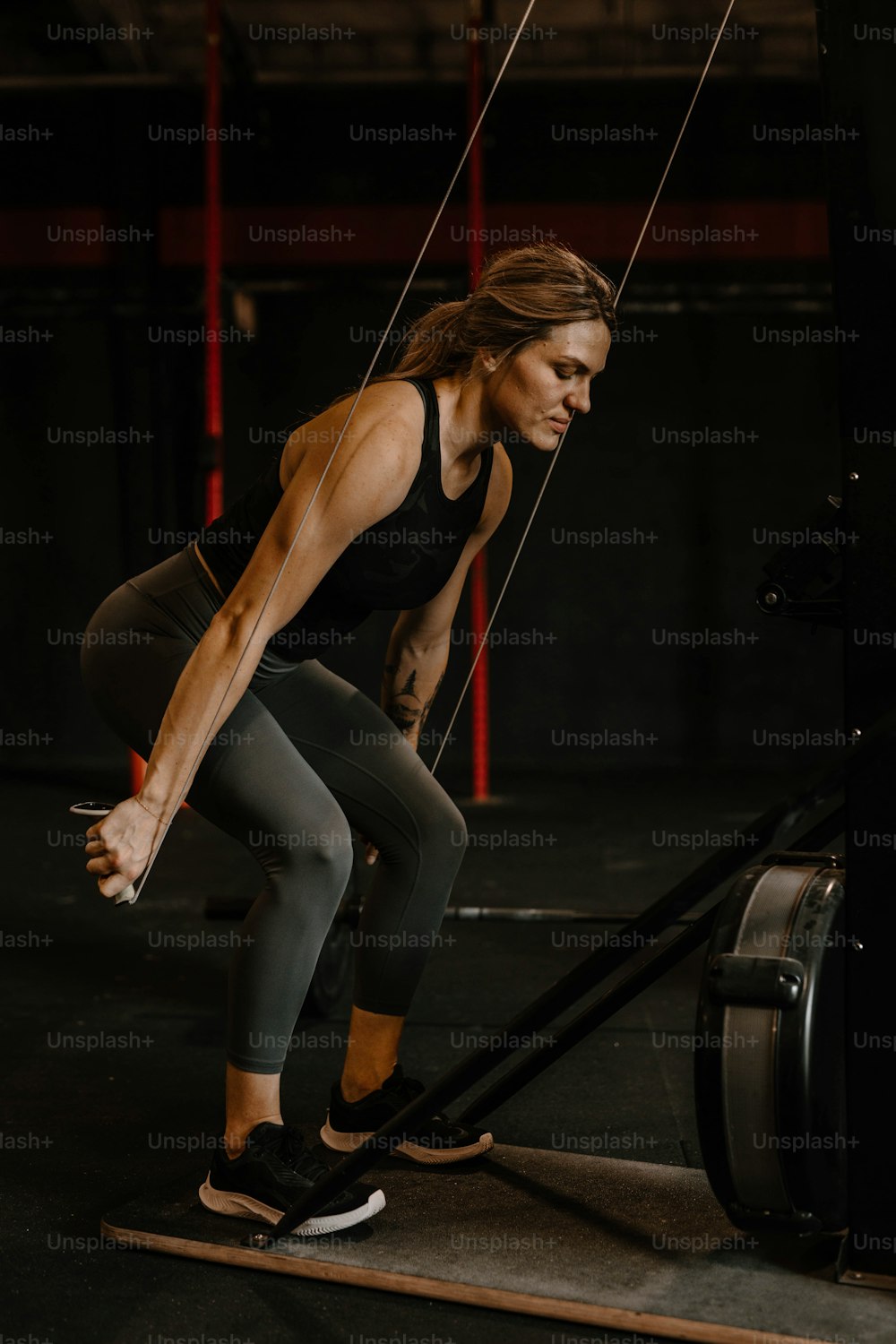 a woman in a black top and leggings doing a pull up