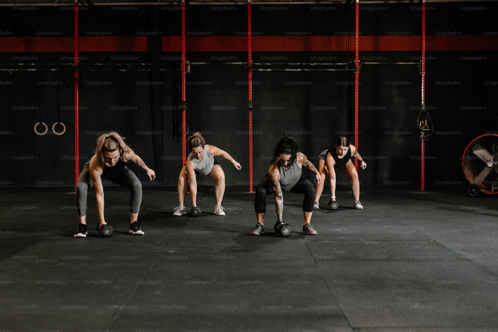 a group of women doing squat exercises in a gym