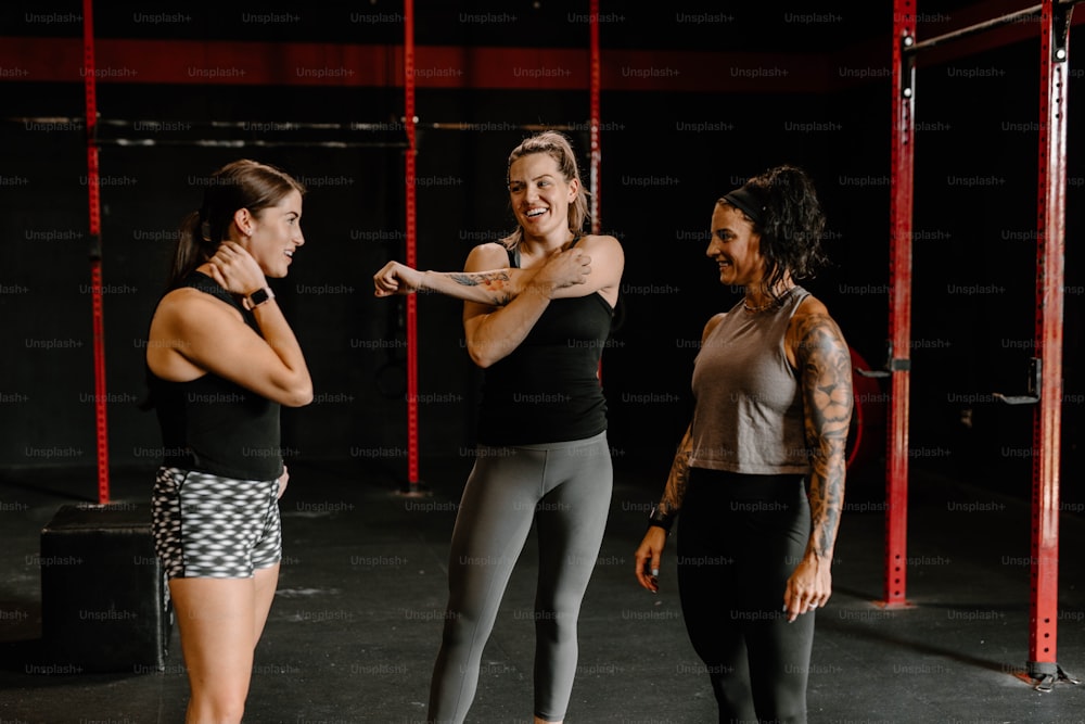 a group of women standing next to each other in a gym