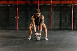 a woman is doing push ups with a kettle