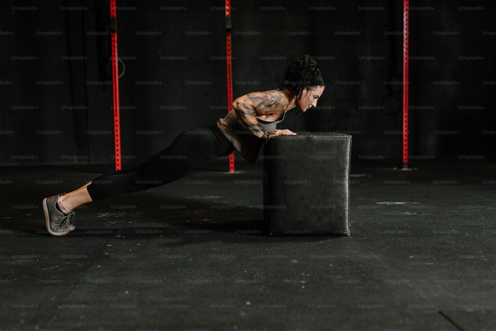 a woman doing a push up on a box