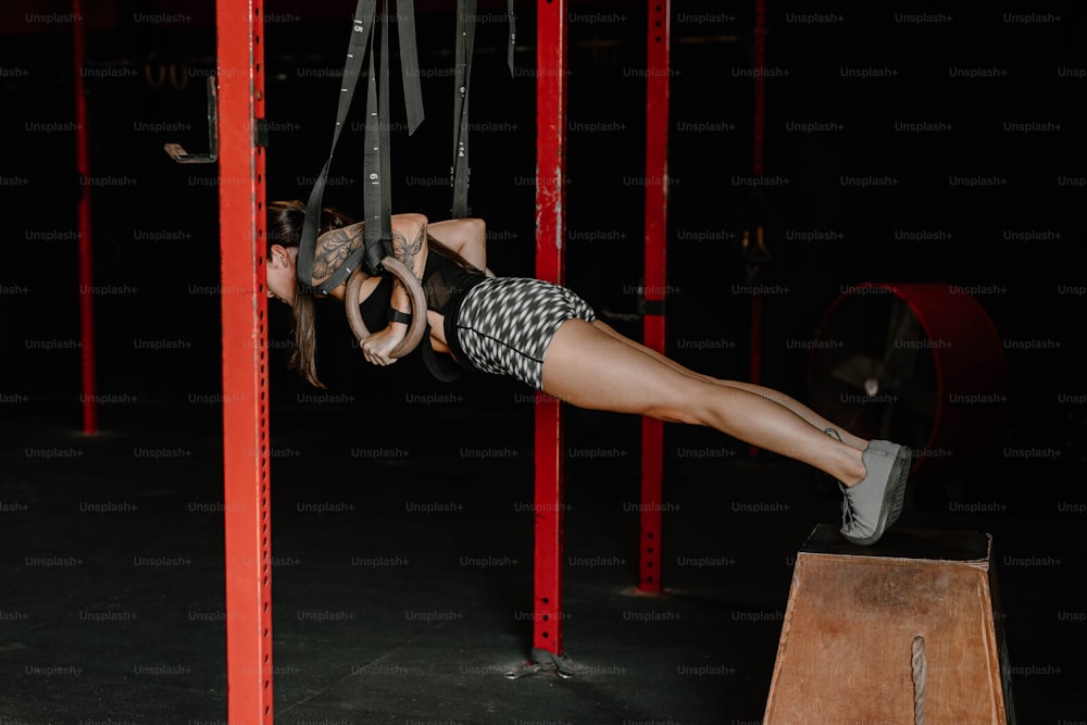 Eine Frau, die kopfüber in einem Fitnessstudio hängt