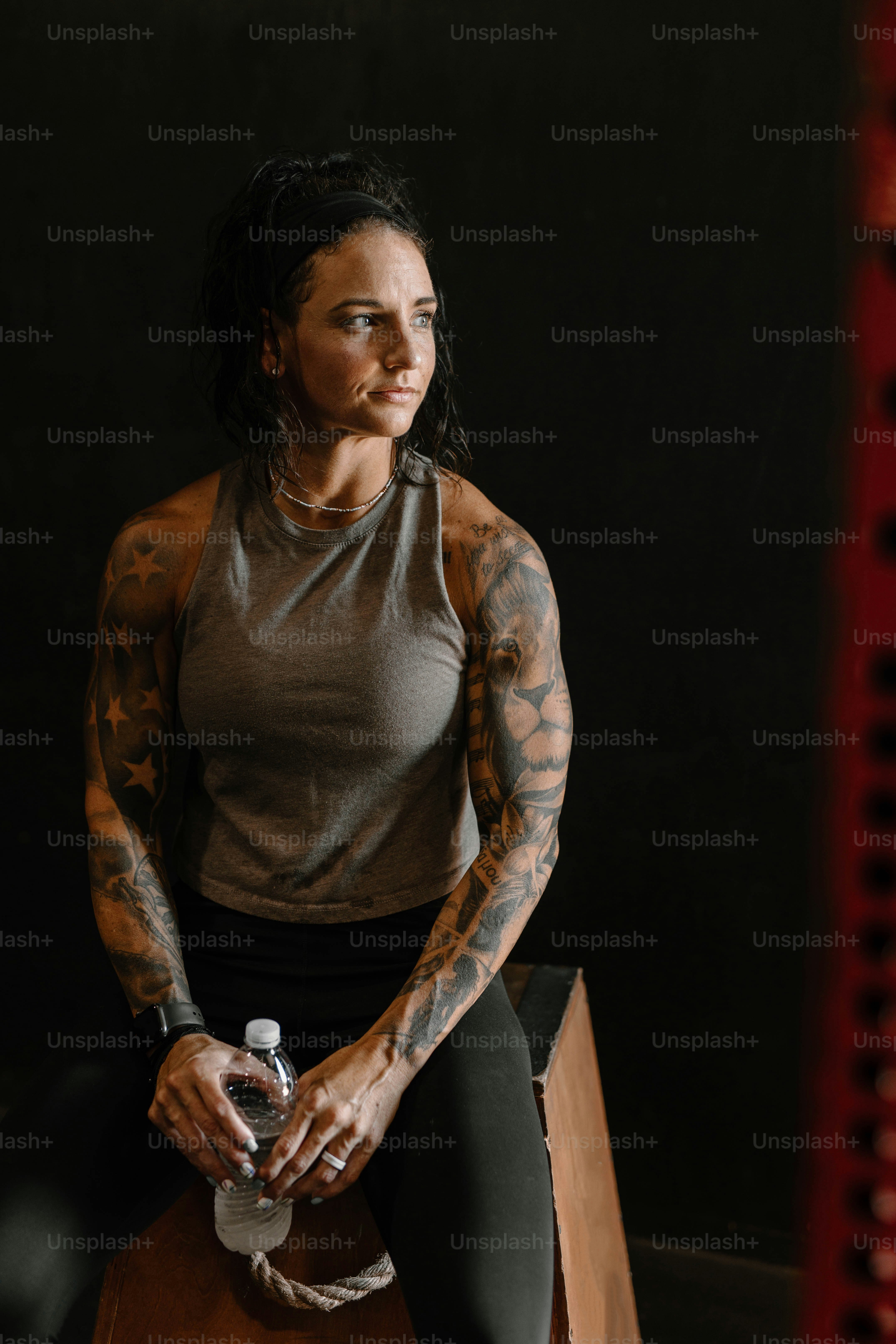 Una mujer con tatuajes sentada en un banco