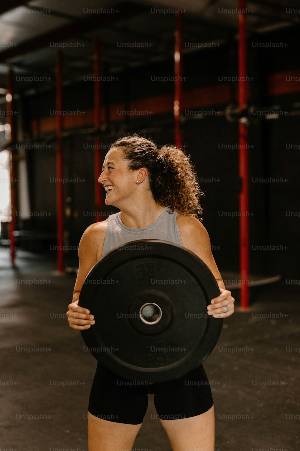 Eine Frau, die eine schwarze Scheibe in einem Fitnessstudio hält