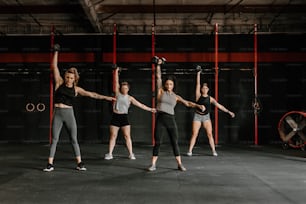 a group of women doing exercises in a gym