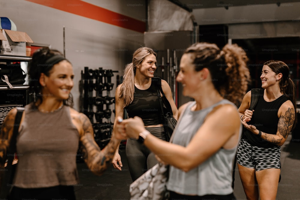 Eine Gruppe von Frauen, die in einem Fitnessstudio umeinander stehen
