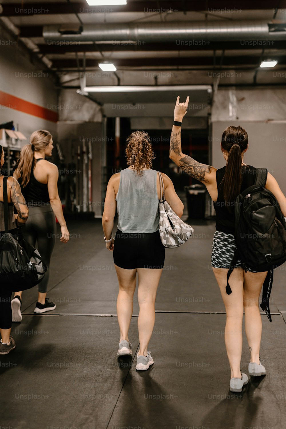 a group of women walking through a gym