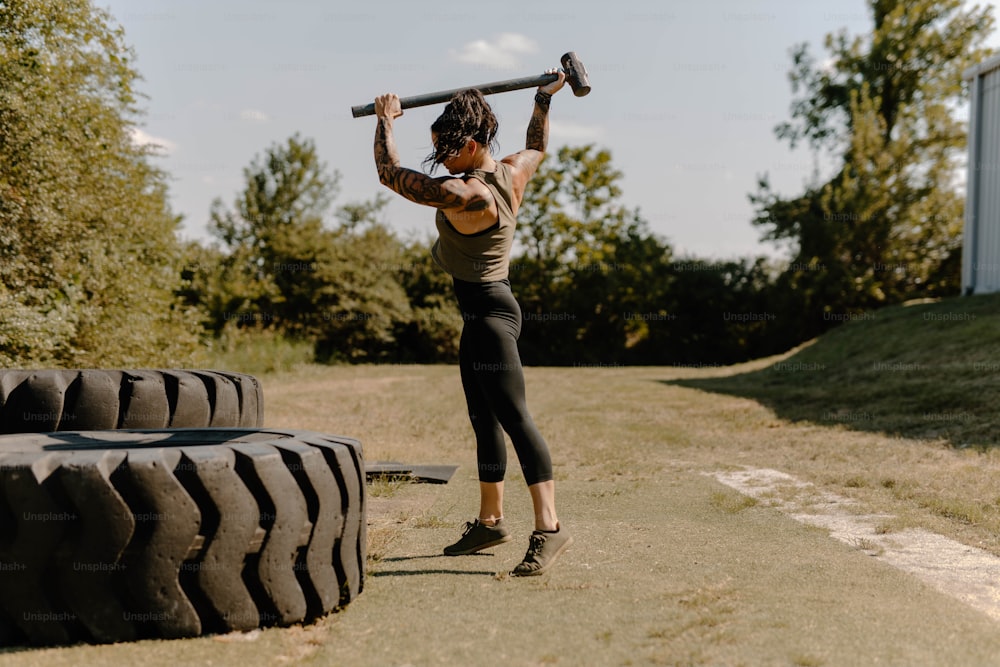 a woman is holding a barbell above her head
