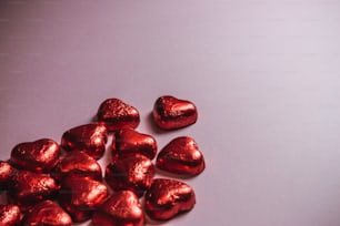 a pile of heart shaped chocolates sitting on top of a table