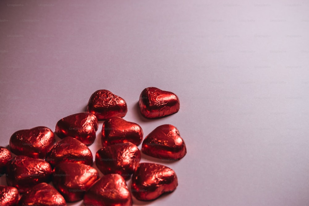 Un montón de chocolates en forma de corazón sentados encima de una mesa