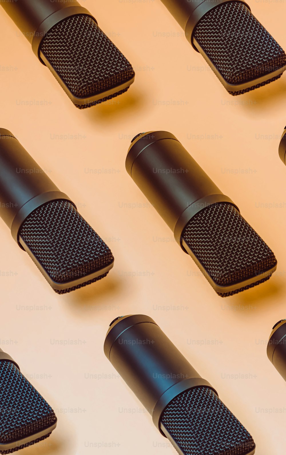 uma fileira de microfones pretos sentados em cima de uma mesa