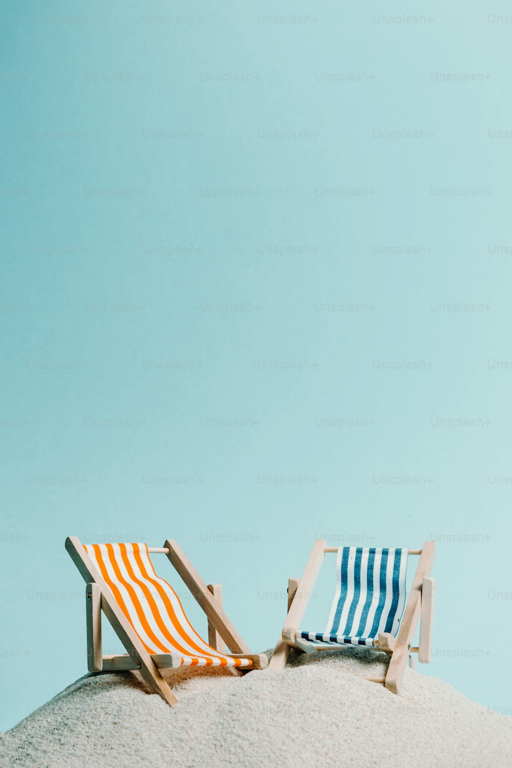 um par de cadeiras sentadas em cima de uma praia de areia