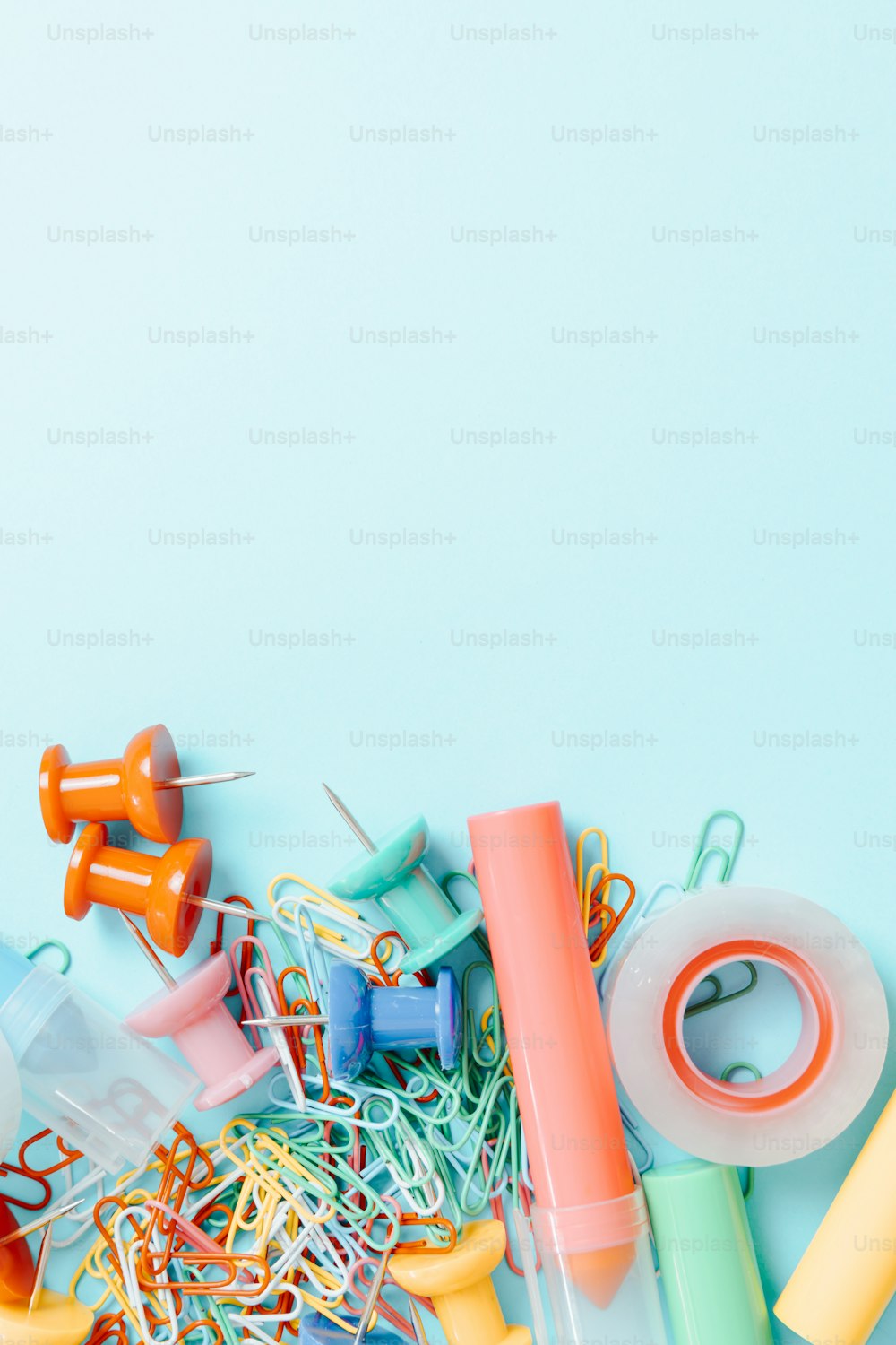 a pile of assorted craft supplies on a blue background